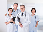 Four Physicians smiling. There is two females and two males