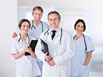 Four Medical Professionals smiling. There is two females and two males.